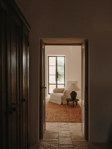 Interior of a minimalist room with a cabinet, glass window, and wooden floors.