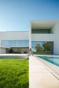 A Modern Residential Exterior with Glass Pool and White Exterior Walls