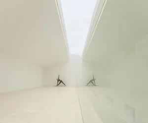 A modern interior space with a white glass ceiling and minimalist design.