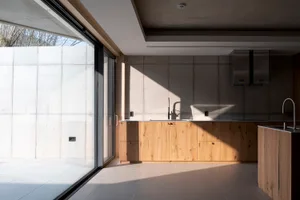 Modern minimalist kitchen with concrete, wood, and stone materials