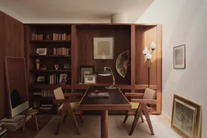 A minimalist home office with wooden elements, including a desk, chairs, and bookshelves filled with books and art.