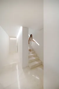 A minimalist interior with a white marble staircase.