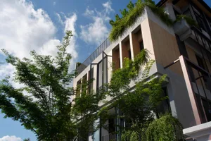 A modern building with a concrete exterior and lush greenery.