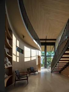 A modern interior with wooden walls and floors, featuring an open space and stairs.