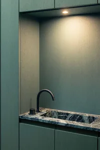 A modern kitchen with a marble countertop and cabinet fronts.