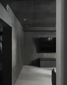 A modern living room featuring minimalist concrete walls and furniture.