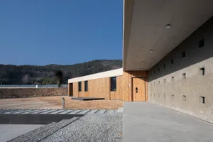 Modern residential entrance featuring minimalist design with wooden panels and concrete structure
