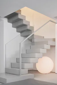 A modern, minimalist staircase with glass and metal elements.