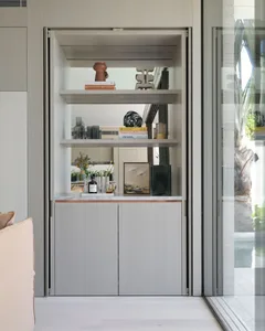 A modern bar with built-in shelves and a marble countertop, featuring various decorative and functional items.