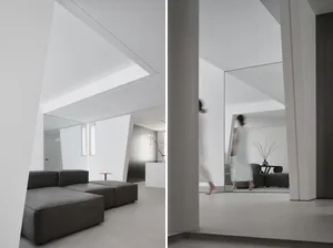 Contemporary living room featuring a minimalist design with exposed concrete walls and a large mirror.