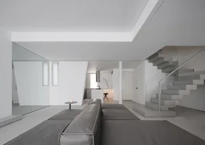 Modern minimalist living room featuring concrete, glass, and metal elements