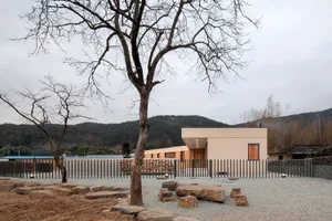A modern residential home with a minimalist exterior featuring wood, stone, and metal.