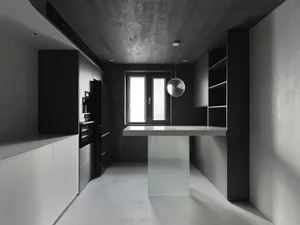 Modern kitchen featuring black and white design with concrete elements