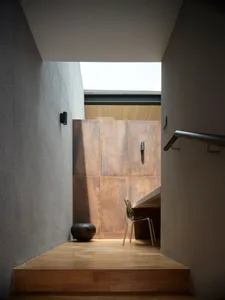 Modern minimalist interior with wooden stairs and floor.