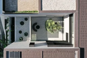 A minimalist terrace featuring concrete, gravel, and a patch of plants.