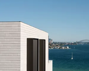 Modern house with concrete exterior overlooking the ocean.