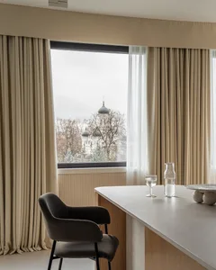 A modern kitchen with transparent curtains and a view outside.