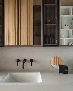 Modern bathroom with concrete countertop and wooden cabinets, featuring a built-in sink, black faucet and handle, and an oval