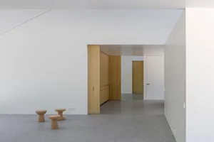 A modern office space with concrete flooring and wooden furniture.
