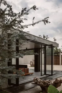 Concrete and glass minimalist residential facade under cloudy skies.