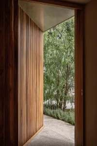 Modern interior featuring a wooden wall and view of outdoor greenery.