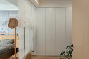 Modern minimalist bedroom with a glass door cabinet and a wooden bed frame and headboard.