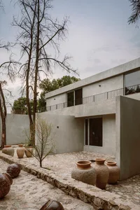 Concrete residential exterior with large windows and minimalistic design features.