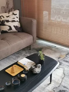 Tea set and cushions on a textured living room wall with blinds and cushions