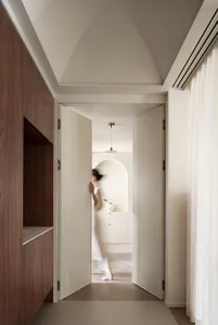 A minimalist residential interior with white walls and a natural wood floor.