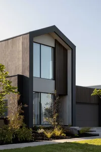 Modern house exterior with concrete walls and wooden accents.