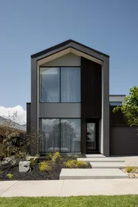 A modern house exterior with concrete, glass, and metal materials.