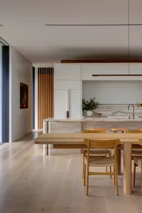 Modern kitchen and dining area featuring wood and marble materials.