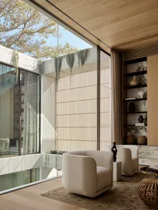 Modern interior design featuring a living room with marble walls and wood flooring.