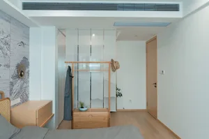 A minimalist bedroom featuring comfortable lightwood furniture and a glass partition.