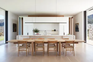 Modern, minimalist kitchen featuring marble countertops, wooden furniture, and sleek, clean lines.