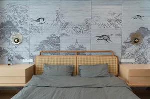 A bedroom with a bed featuring rattan headboard and gray bedding, against a wall with illustrated natural landscapes.