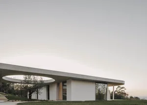 Modern, minimalist house with concrete walls and circular windows.