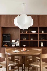 A modern residential space featuring wooden furniture and a large pendant light.