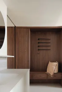 Modern wooden closet storage with towel racks and drawers.