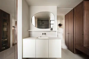 Modern minimalist bathroom with white cabinets, marble countertop, and wooden cabinets.