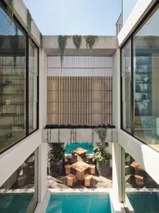 Modern interior design featuring concrete and glass materials on a terrace with outdoor seating and a swimming pool.