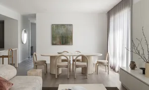 Modern interior design featuring a stone dining table and fabric chairs.
