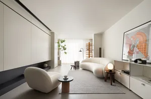 A modern white interior living room with a curved sofa, minimalist design, and white furniture.