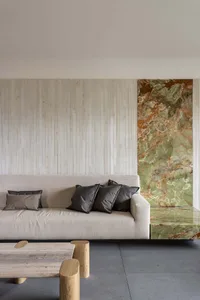 Modern living room featuring minimalist furniture, marble accents, and concrete floor.
