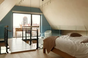 Modern bedroom featuring wooden furniture and a glass balcony overlooking a cityscape.