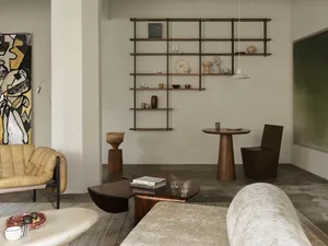 A modern industrial living room with concrete elements, minimalist furniture, and a variety of home decor items.