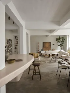 A modern living room featuring a concrete floor, minimalist design, and contemporary furniture.