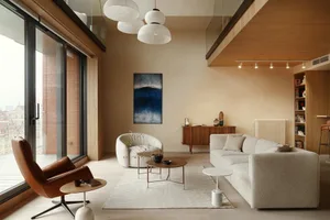 Modern living room with wooden furniture, neutral color palette, and large windows.