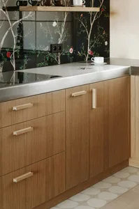 Modern, minimalist kitchen with wooden cabinets and stainless steel countertops.