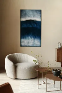 Modern minimalist living room featuring a fabric accent chair with a large abstract blue painting on the wall.